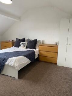 This inviting double bedroom features a cozy at...