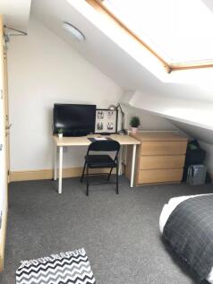 This cozy double bedroom features ample natural...