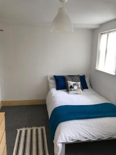 This inviting double bedroom features a cozy at...