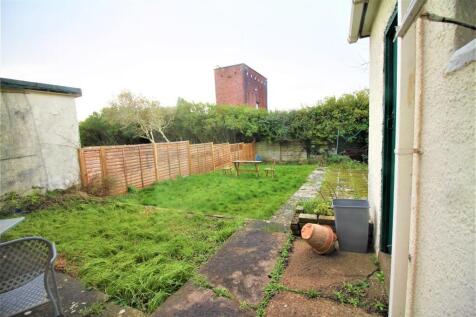 A charming garden space featuring ample greener...
