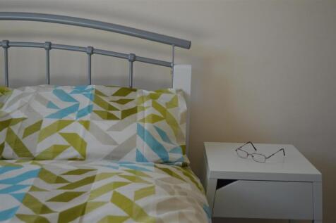 This cozy double bedroom features a stylish geo...