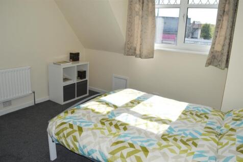 This cozy double bedroom features ample natural...
