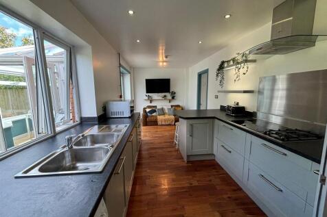 This modern kitchen features sleek countertops ...