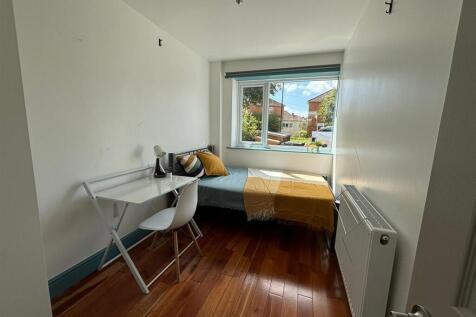 This cozy double bedroom features a bright wind...
