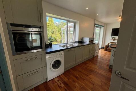 This modern kitchen features sleek cabinetry an...