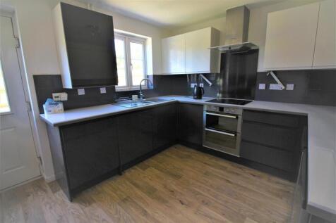 A modern kitchen featuring sleek cabinetry, amp...