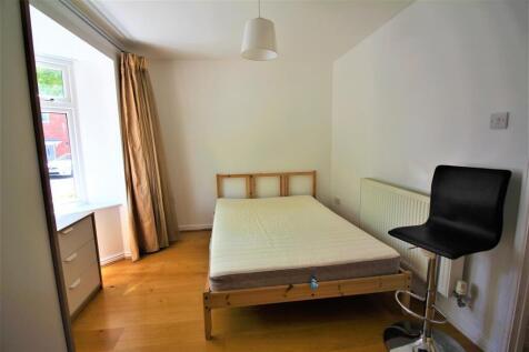 This inviting double bedroom features warm wood...
