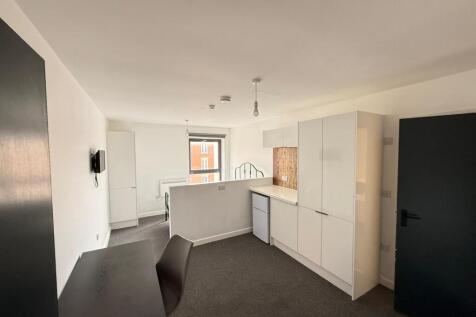 Modern kitchen area featuring sleek cabinetry a...