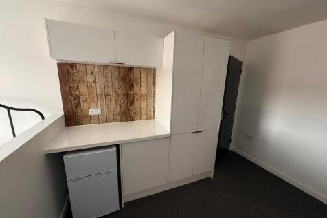 Modern kitchenette featuring sleek cabinetry an...