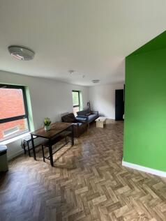 This spacious living room features large window...