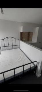 This spacious double bedroom features a modern ...