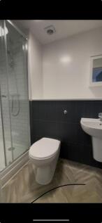 A modern bathroom featuring a sleek shower area...