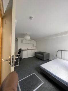Stylish double bedroom featuring a cozy sofa an...