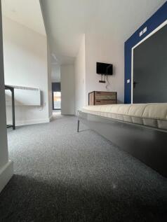 A spacious double bedroom featuring a cozy bed,...
