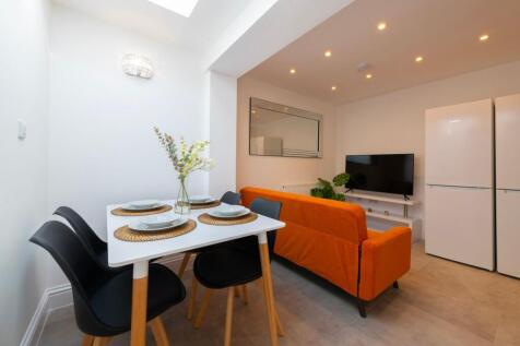 This vibrant living room features a stylish ora...