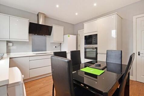 This modern kitchen features sleek cabinetry, a...