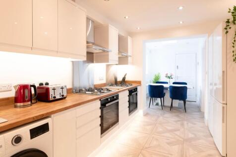 This modern kitchen features sleek cabinetry, a...