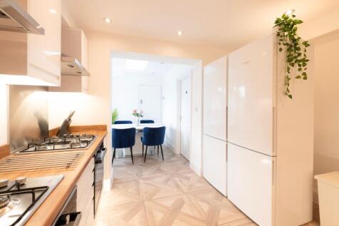 Modern kitchen featuring sleek cabinetry, ample...