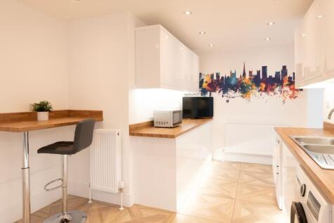This modern kitchen features sleek cabinetry, a...