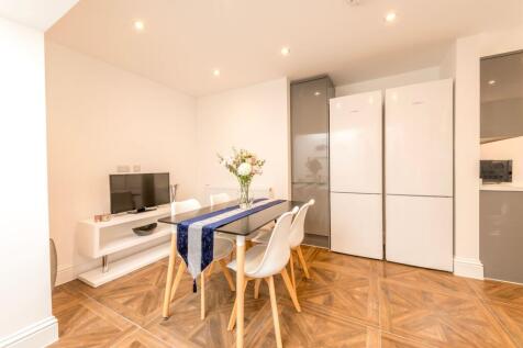 This modern kitchen features sleek white applia...