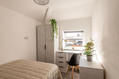 This inviting double bedroom features a cozy at...