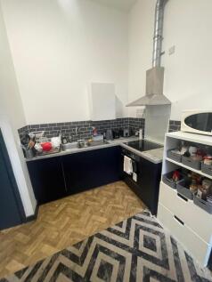 This modern kitchen features sleek black cabine...