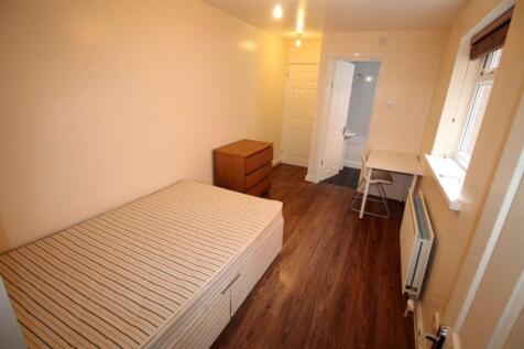 A cozy double bedroom featuring warm wooden flo...