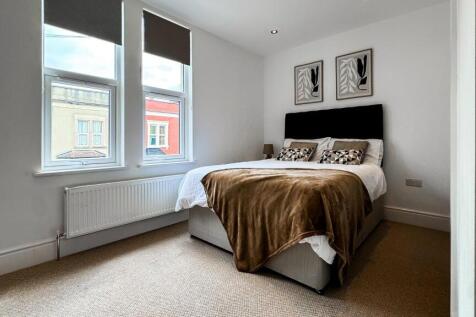 This inviting double bedroom features a comfort...