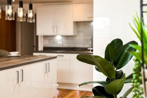 A modern kitchen featuring sleek white cabinetr...