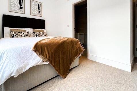 This inviting double bedroom features a cozy at...