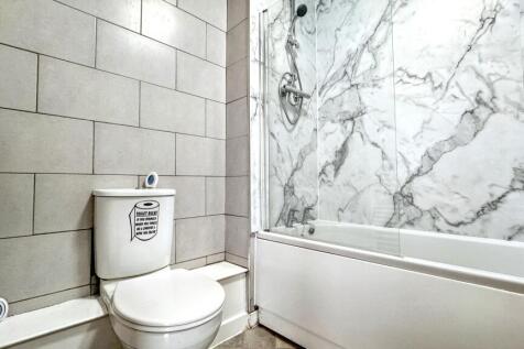 This stylish bathroom features elegant marble a...