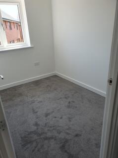 A cozy double bedroom featuring soft gray carpe...