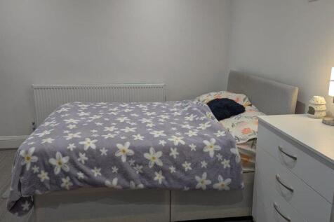 This cozy double bedroom features a comfortable...