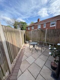 A cozy and well-maintained garden patio area wi...