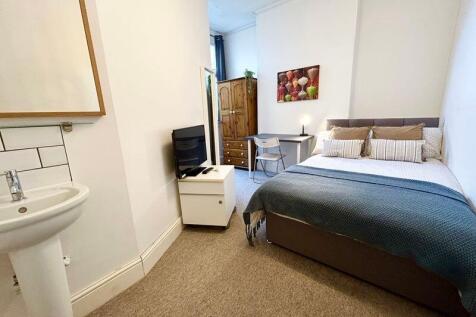 A charming double bedroom featuring a cozy bed,...