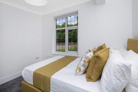 This charming double bedroom features a cozy be...