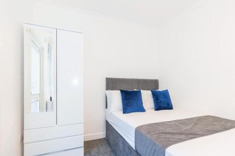 This cozy double bedroom features a comfortable...
