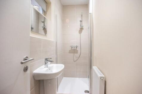 A modern bathroom featuring sleek tiles, a spac...