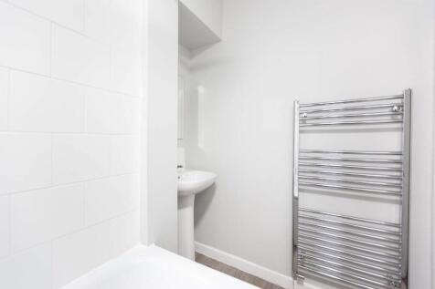 A modern bathroom featuring sleek white tiles a...