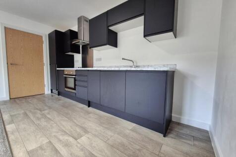 Modern kitchen featuring sleek black cabinetry ...