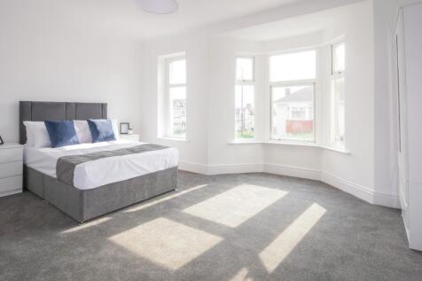Spacious double bedroom featuring large windows...