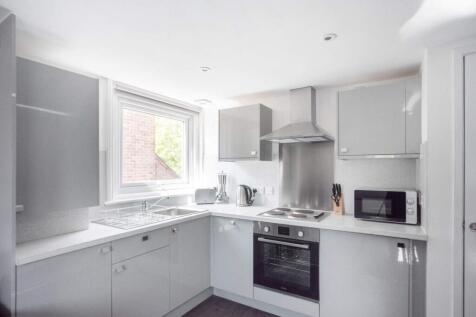 A modern kitchen featuring sleek grey cabinets ...