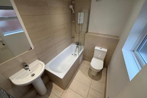 A modern bathroom featuring a sleek bathtub, a ...
