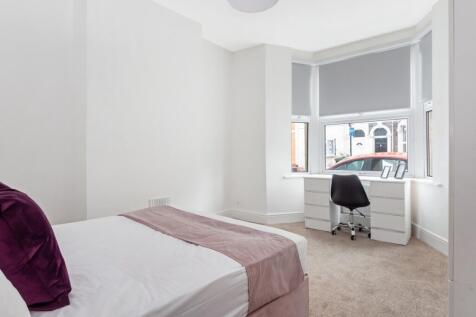 This inviting double bedroom features a cozy at...