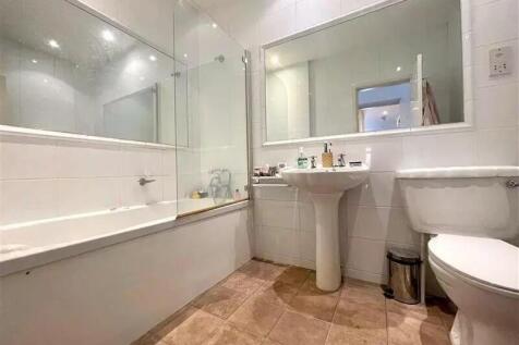 This spacious bathroom suite features a modern ...