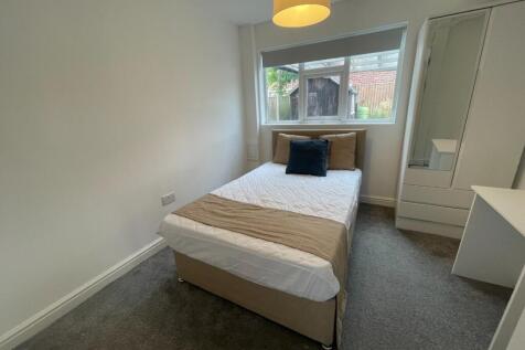 This inviting double bedroom features a cozy be...