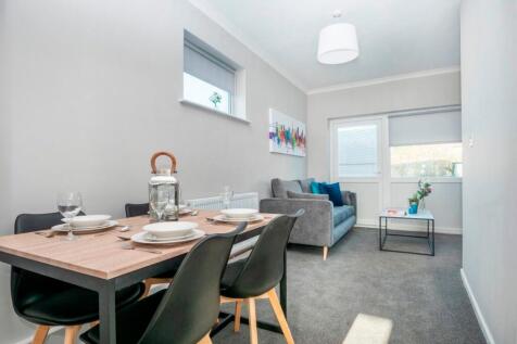 A bright and inviting living room featuring a c...