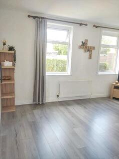 A bright and airy living room featuring large w...