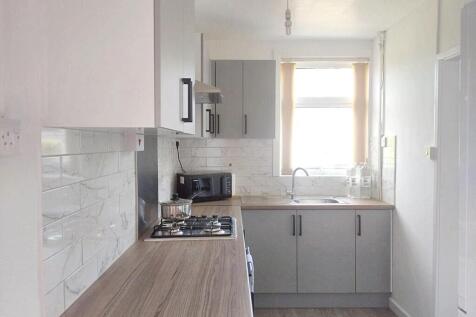 A bright and modern kitchen featuring ample nat...