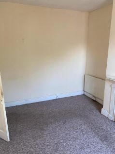 A simple, clean bedroom with neutral walls and ...